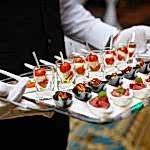 server holding a tray of appetizers at a banquet